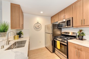 Kitchen with Hardwood Inspired Floors, Oven, Sink, Refrigerator and Wood Cabinets
