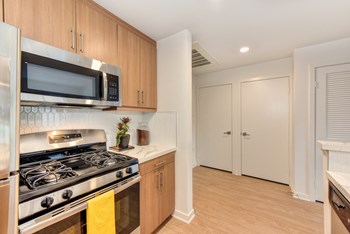 Kitchen with Gas Stove, Refrigerator and Wood Cabinets