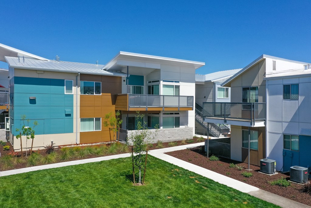 Apartment Exterior with Walking Path, Grass, Wood Chip Floor, Blue Apartment Exterior at Addison Ranch Apartments, Petaluma, California
