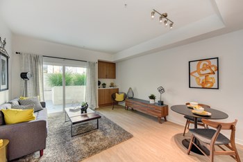 Living Room with hardwood Inspired floors and Patio, Chairs and Painting on Wall