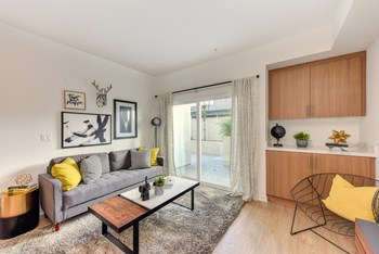 Living Room with Wood Cabinets, Gray Sofa, and Patio View