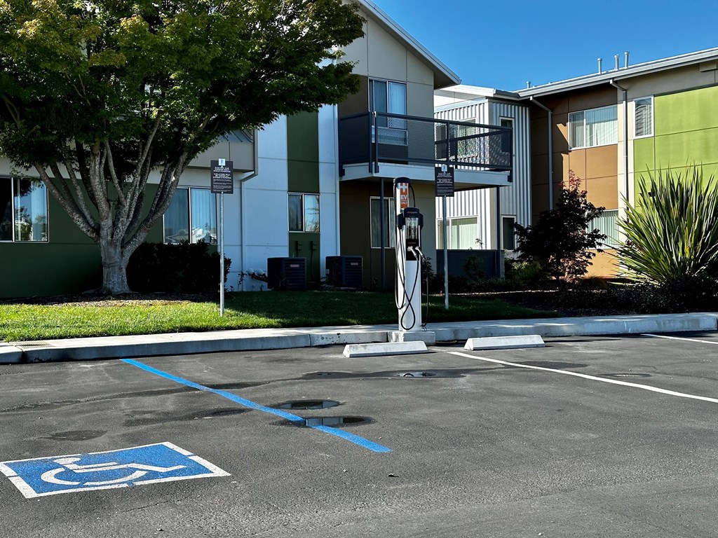 An empty parking lot with Electric Car Charging Stations Available at Addison Ranch Apartments, Petaluma, CA, 94954