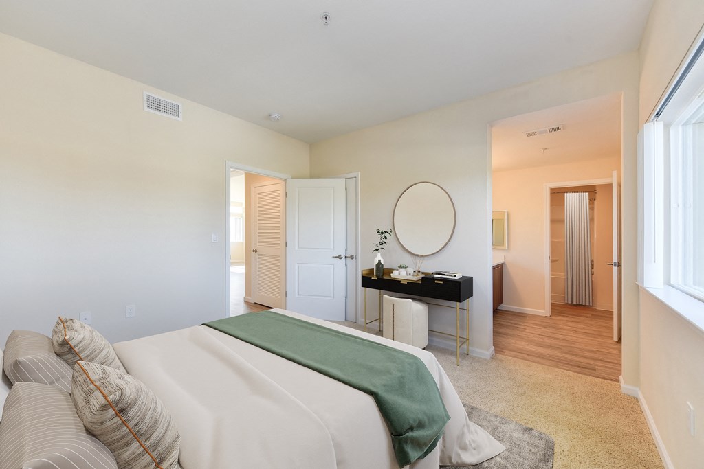 a bedroom with a large bed and a desk with a mirror