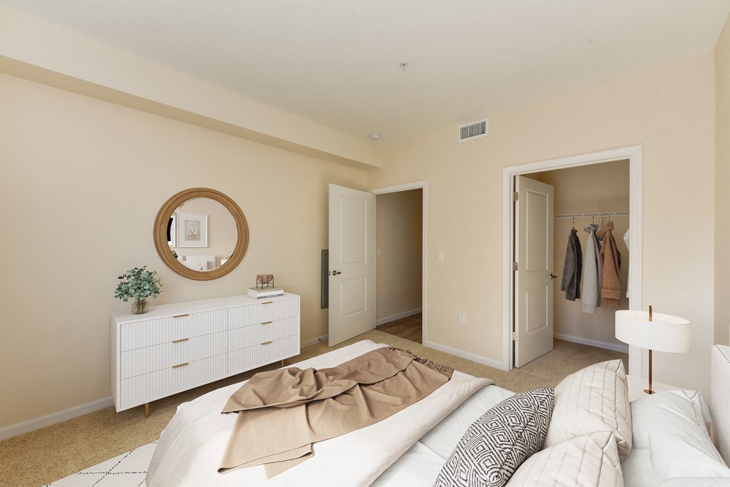 a bedroom with a bed and dresser and a closet