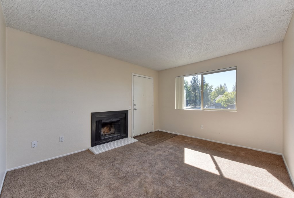 Upstairs vacant home with plush carpeting, and fireplace located in the living room.