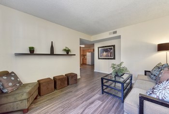 Furnished living room with couch, coffee table, side chair and floor lamp in the corner. - Photo Gallery 2
