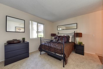 Furnished bedroom with bed, dresser and nightstand. - Photo Gallery 6