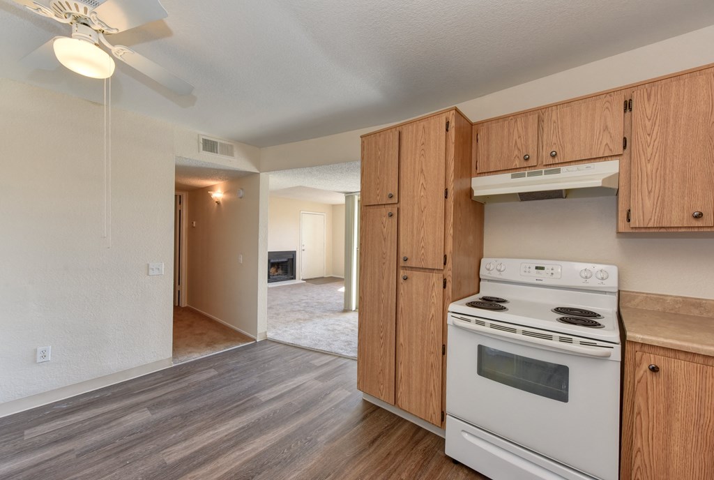 Upstairs Vacant Kitchen with white stove and oven with light brown cabinetry.