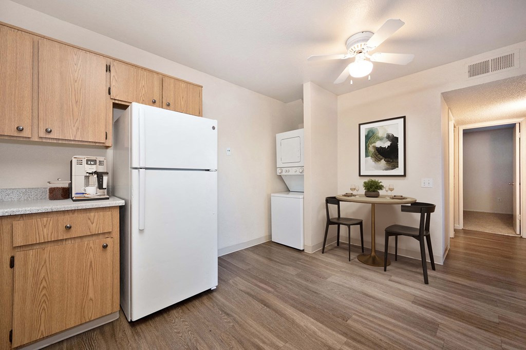 our apartments offer a kitchen and dining area with a white refrigerator and in-home washer and dryer 
