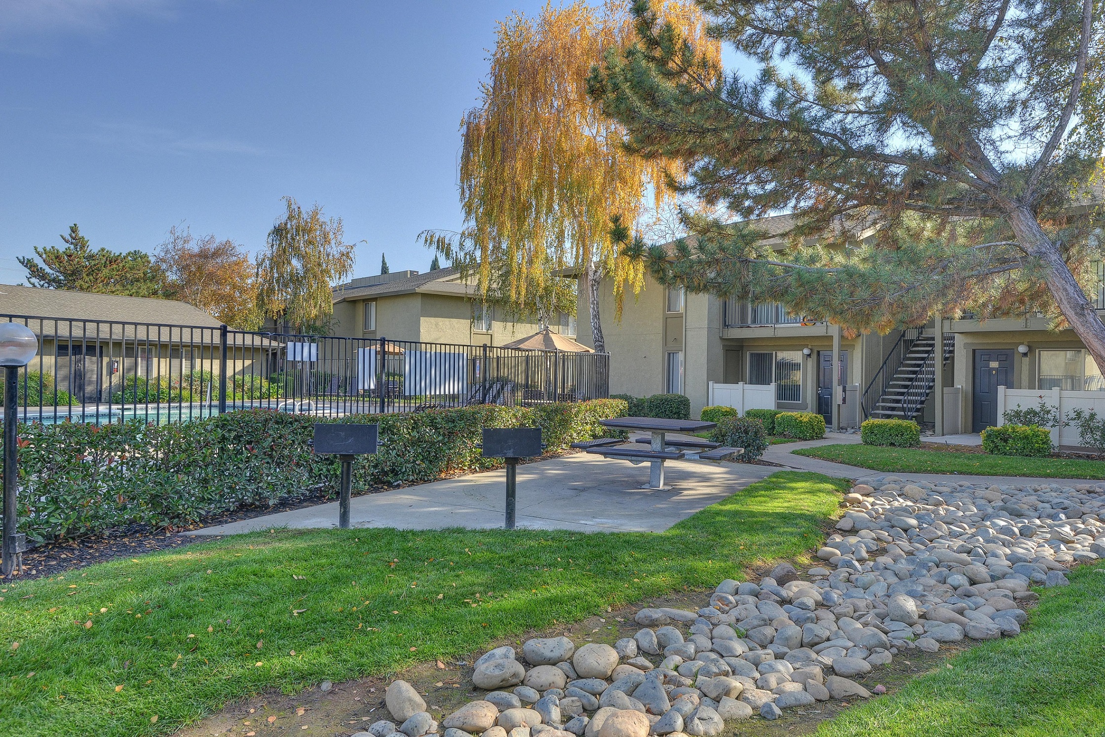 BBQ and Picnic Area with Table, Grass, Gate, and Pool View