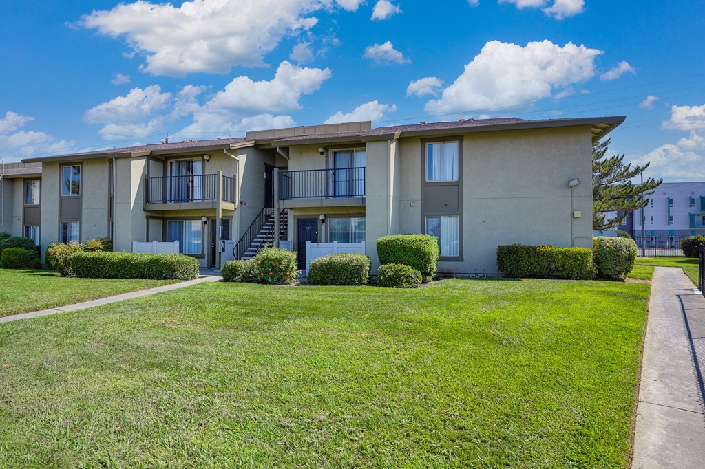 Breckenridge Village Community grounds and exterior of an apartment building with grass outside and blue skies