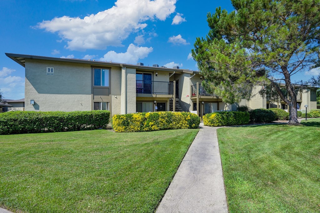 Exterior of the Breckenridge Apartment building with a lawn and trees in front of it