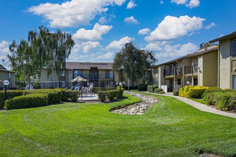 Breckenridge Village Community grounds and exterior of an apartment building with grass outside and blue skies