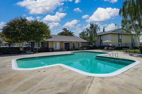 Breckenridge Village swimming pool area with trees surrounding and blue skies