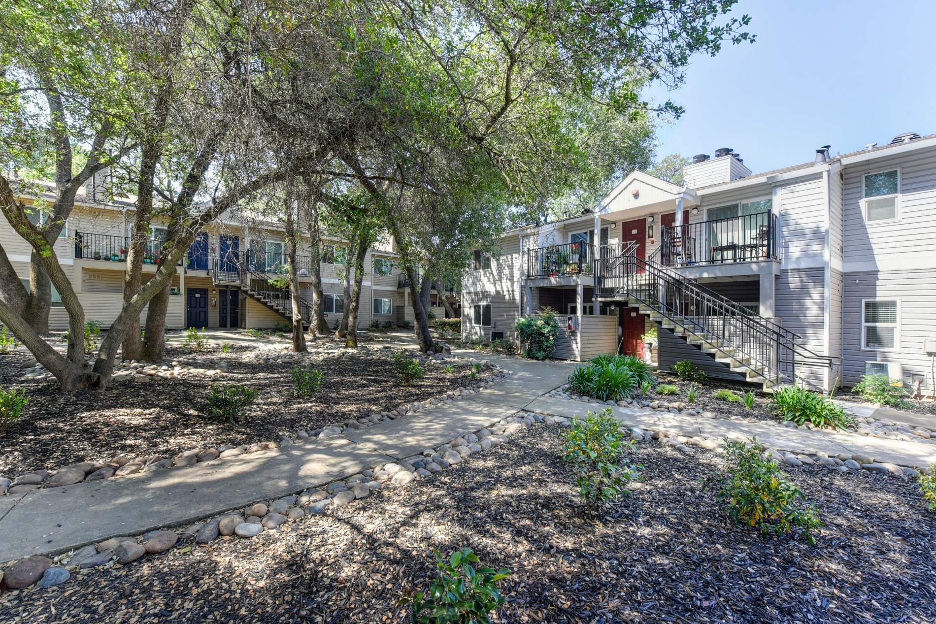 Apartment Exterior with Trees, Bushes and Walkway at Hidden Oaks Apartments, California
