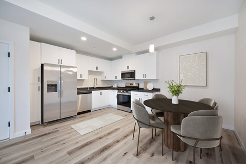 A modern kitchen with a dining table set for four.