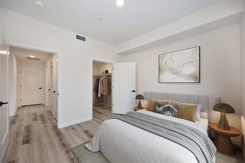 A bedroom with a large bed and a painting on the wall.