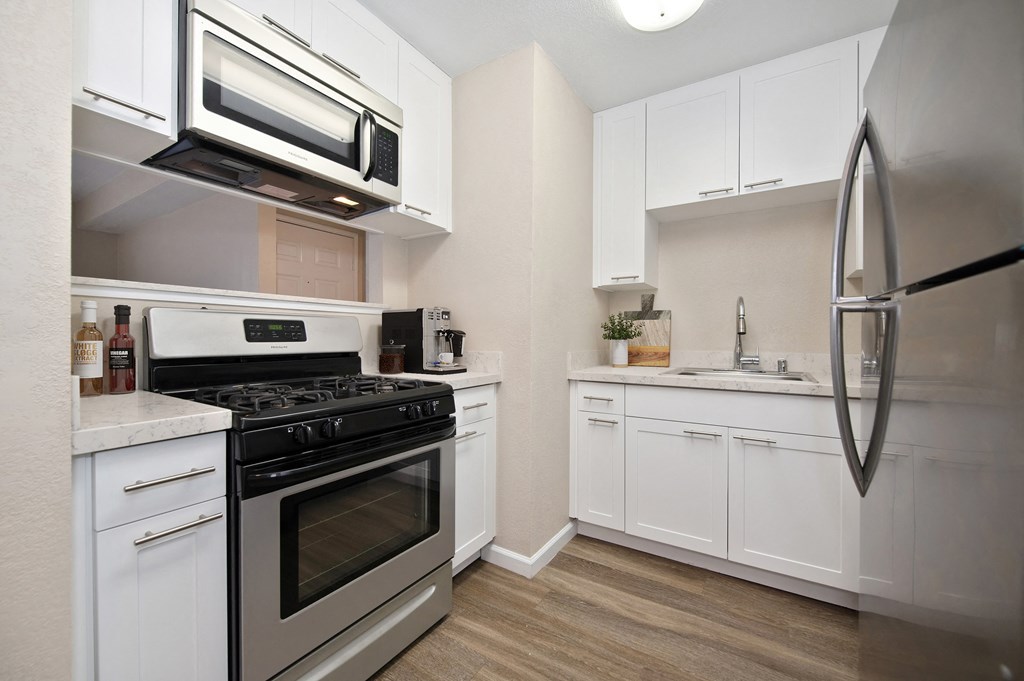 a kitchen with stainless steel appliances and white cabinets