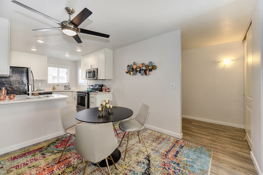 Dining Room with Rug, Hardwood Inspired Floor, Ceiling Fan/Light and Round Black Table at The Legacy Apartments, Antelope, 95843