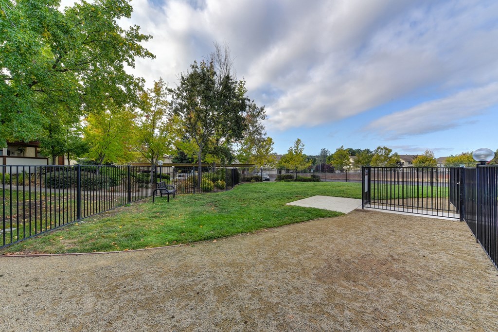 Dog Park with Walking Path, Grass, Trees and Bench in Distance at Rocklin Manor  Apartments, Rocklin  , CA