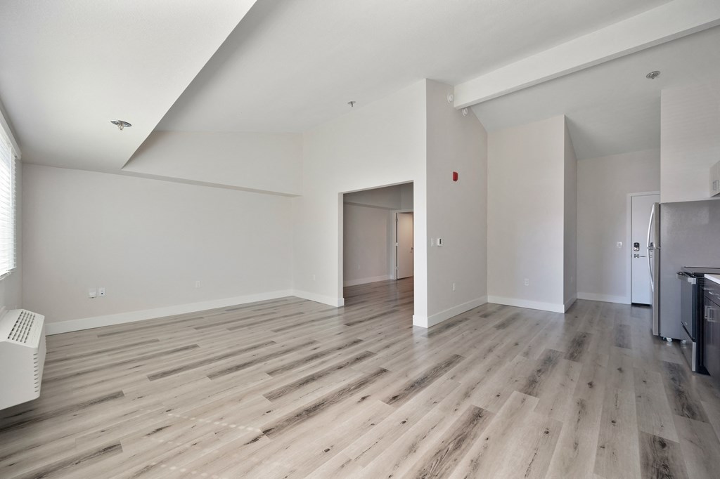 a renovated living room with hardwood floors and white walls  at Track 281 Apartments, Sacramento, CA, 95811