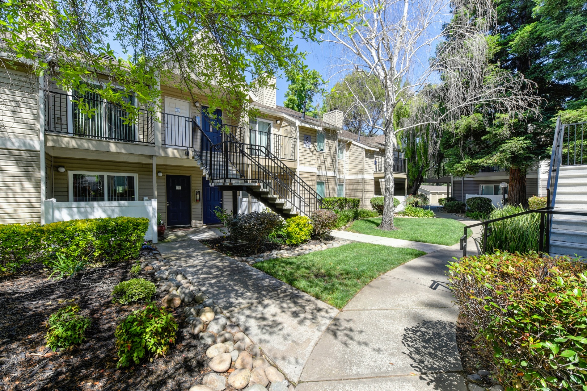 Apartment Exterior Walkways with View of Private Patios, Trees, Bushes and Walkway at Hidden Oaks Apartments, Citrus Heights, 95621