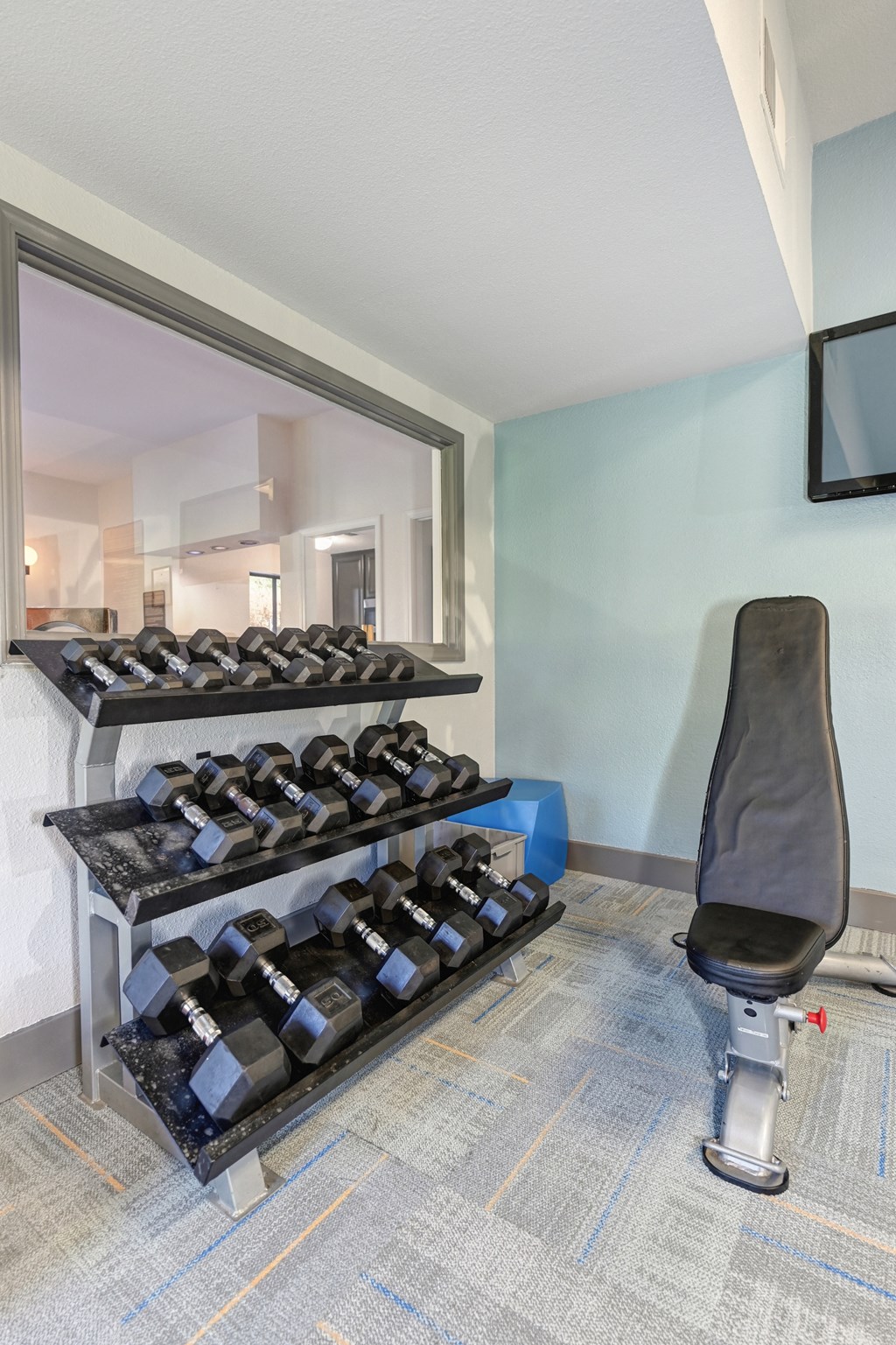 Community fitness center with free weights and bench at Fountains of Fair Oaks, Fair Oaks California