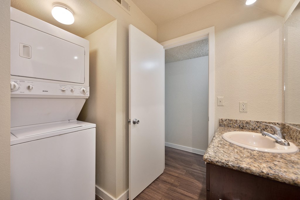 a kitchen with a washer and dryer and a sink and a laundry room at Fountains of Fair Oaks, California