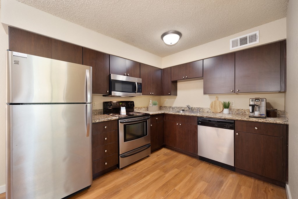 a kitchen with stainless steel appliances and wooden cabinets at Fountains of Fair Oaks, California