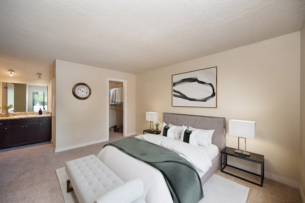 a bedroom with a large bed and a bathroom with a sink at Fountains of Fair Oaks, California