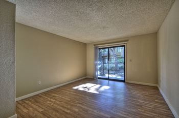 Vacant apartment home with hardwood inspired flooring through out.  Views of the sliding glass patio door.at Fountains of Fair Oaks, Fair Oaks California