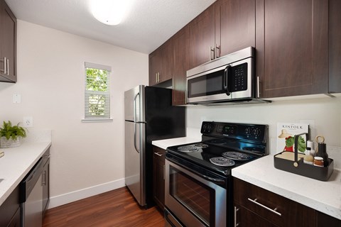 a kitchen with black appliances and a stainless steel refrigerator