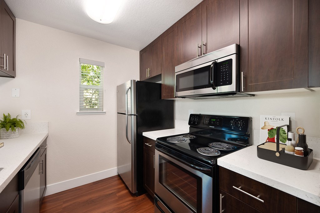 a kitchen with stainless & black appliances and electric stovetop. a kitchen with stainless & black appliances and electric stovetop at Folsom Ranch, California, 95630
