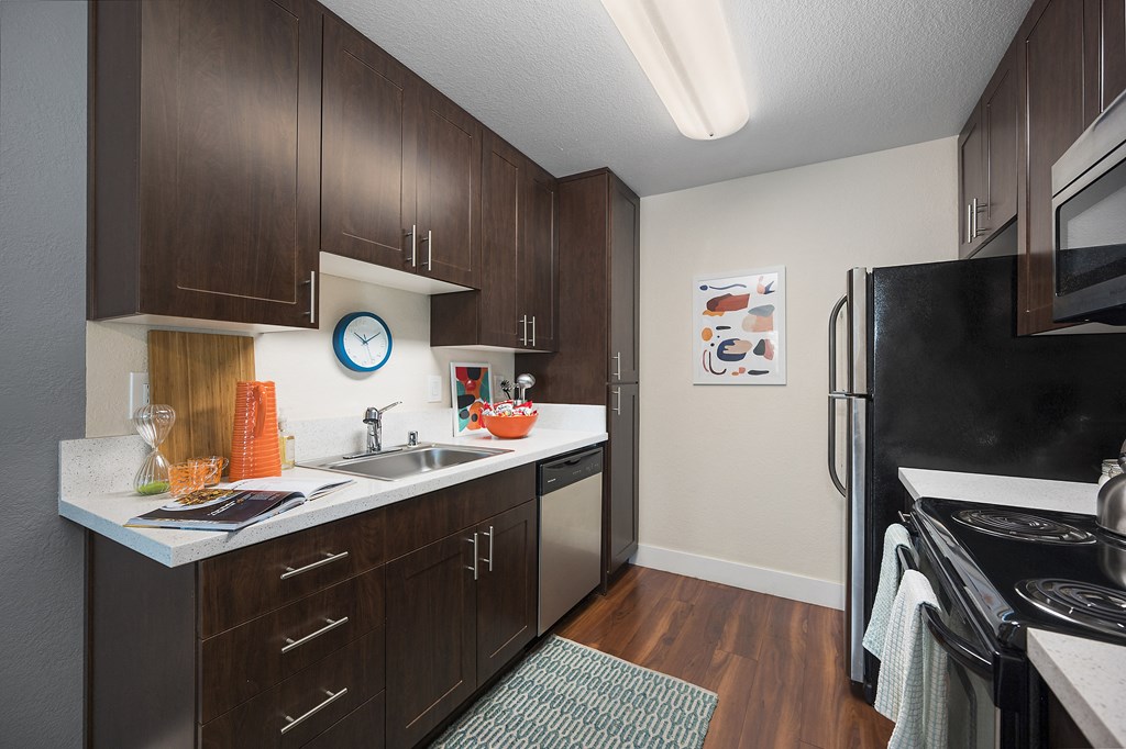 a kitchen with dark wood cabinetry and white countertops at Folsom Ranch, California