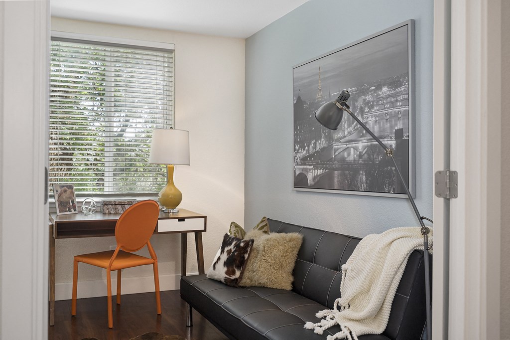 a desk with a lamp and a chair in a room with a couch and a window at Folsom Ranch