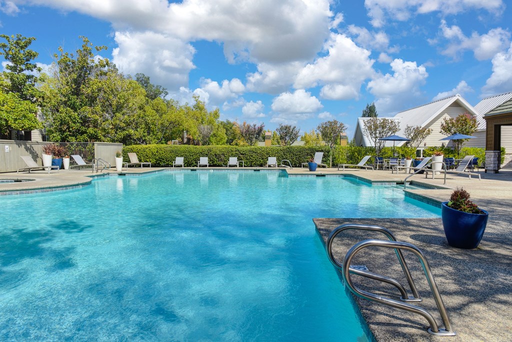 Large swimming pool with lounge chairs around the deck, potted platers and tables & chairs at Folsom Ranch, Folsom, 95630