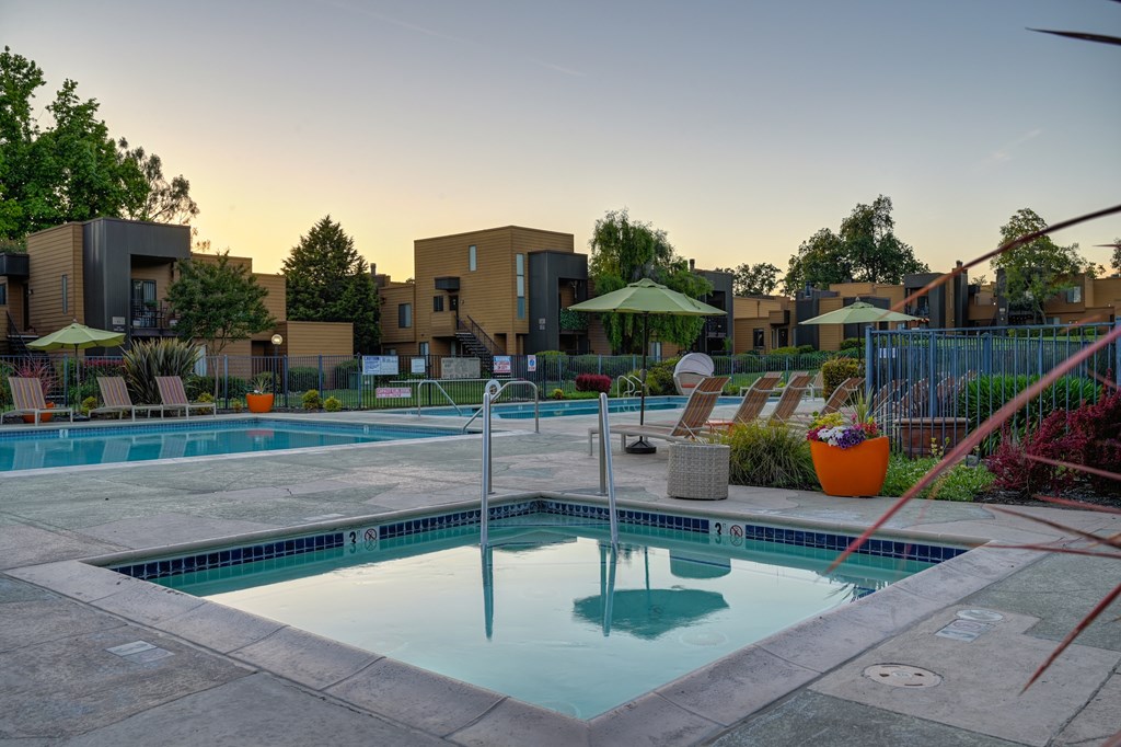 A swimming pool surrounded by a patio and a fence.