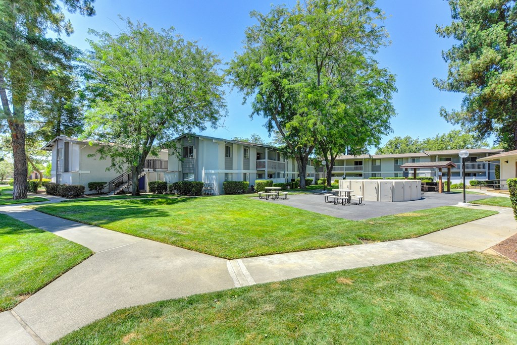 Exterior of the building with large green lawns, walk ways and Trees at Renaissance Park Apartments, Davis, CA, 95618