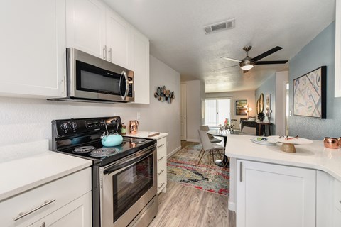 a kitchen with white cabinets and a stainless steel stove and microwave