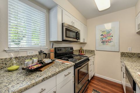 Kitchen with Granite Countertops, Hardwood Inspired Floors and Oven at Hidden Oaks Apartments, Citrus Heights, 95621