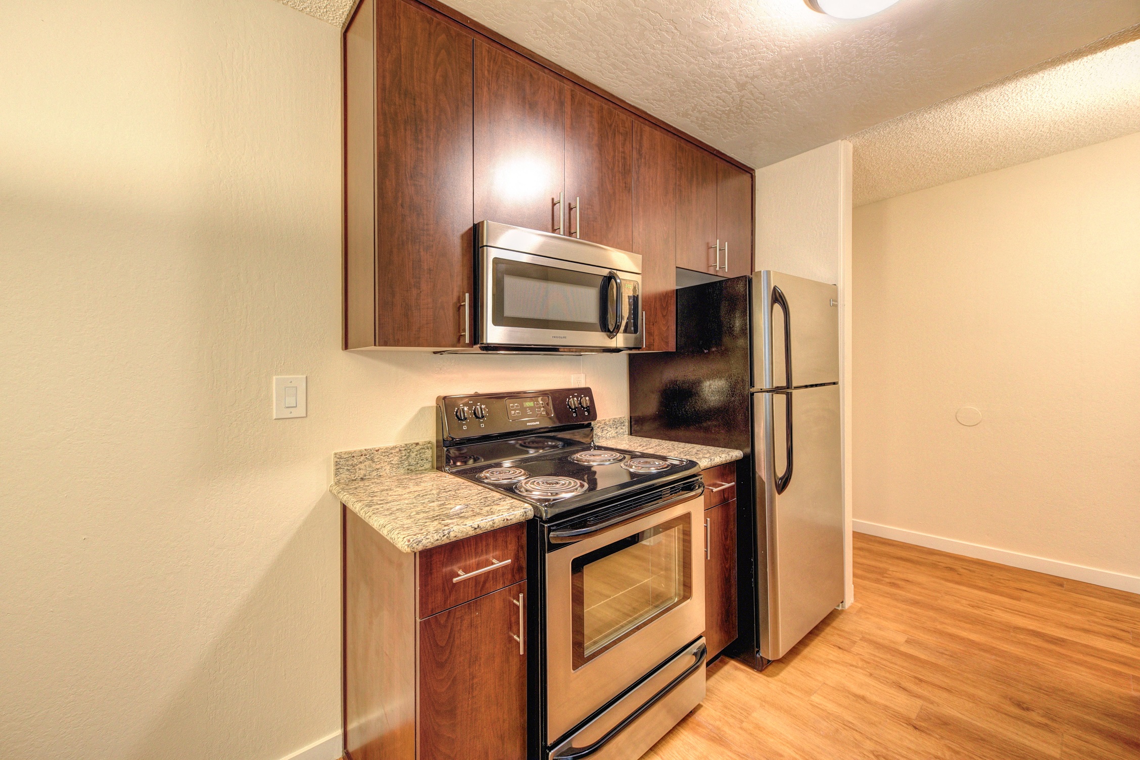 Kitchen with Wood Inspired Floors, Oven, Microwave and Refrigerator at The Retreat at Walnut Creek, Walnut Creek, CA