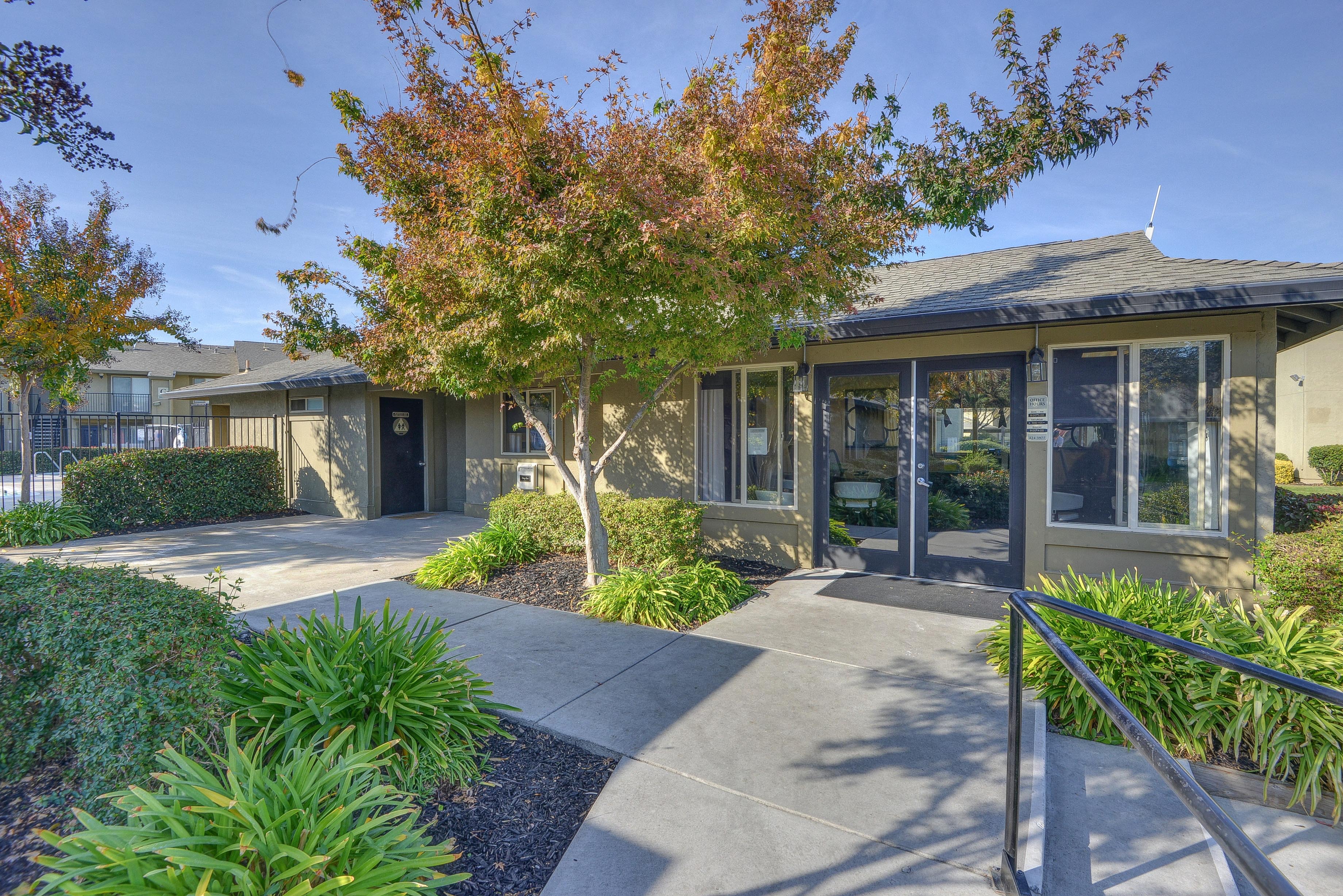 Leasing Office Entrance with Grass, Walkway, Trees with Orange/Brown Leaves