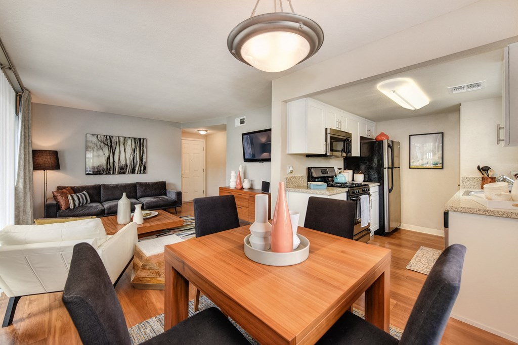 Living Room with Wooden Table, Black Chairs, View of Kitchen with Fridge/Freezer, Oven, Stove, Wood Inspired Floor at Addison Ranch Apartments, California, 94954