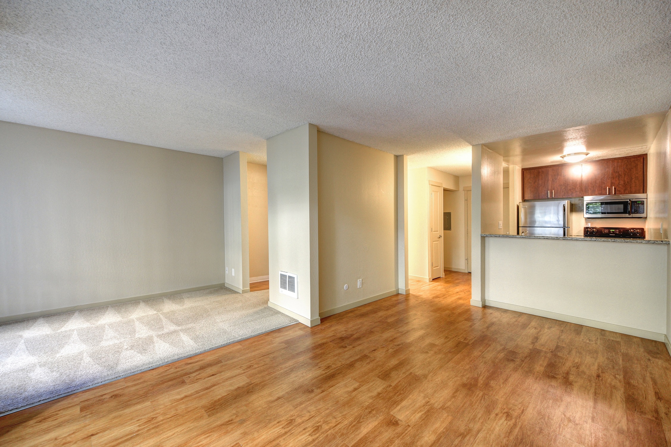 Living Room with Wood Inspired Floors, White Walls and View of Kitchen at The Retreat at Walnut Creek, Walnut Creek, California