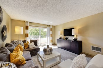 Model home living room with lots of natural lighting coming from the sliding glass patio doors. - Photo Gallery 6