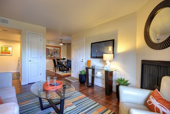 Living Room Facing Entrance Living Room Facing Entrance with Hardwood Inspired Floor, Rug, Glass Table, Round Wall Mounted Mirror, White/Gray Sofa, and Flat Screen Television - Photo Gallery 6