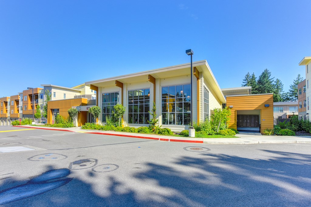 Outside of the fitness center building looking towards the large windows. Community mailboxes are to the right of the fitness center.