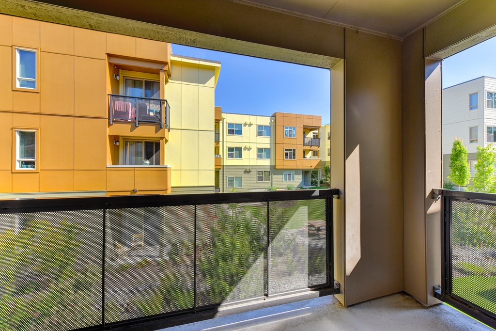 Apartment balcony on second floor over looking the community grounds with blue skies.