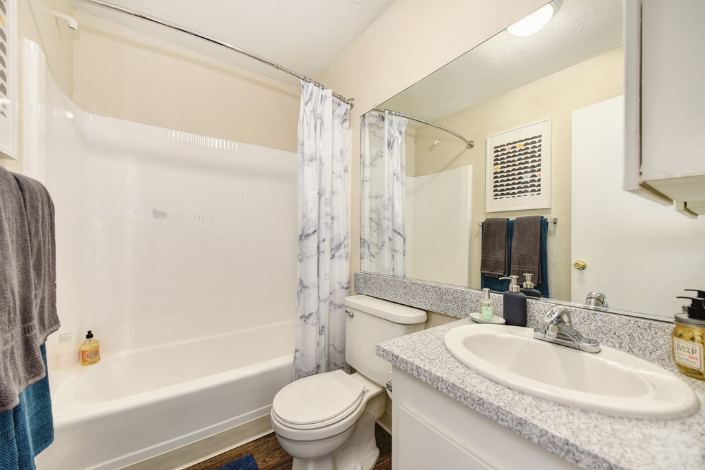 Bathroom with Hardwood Inspired Floor, Toilet, Bathtub and Sink at The Renaissance Apartments, California, 95610