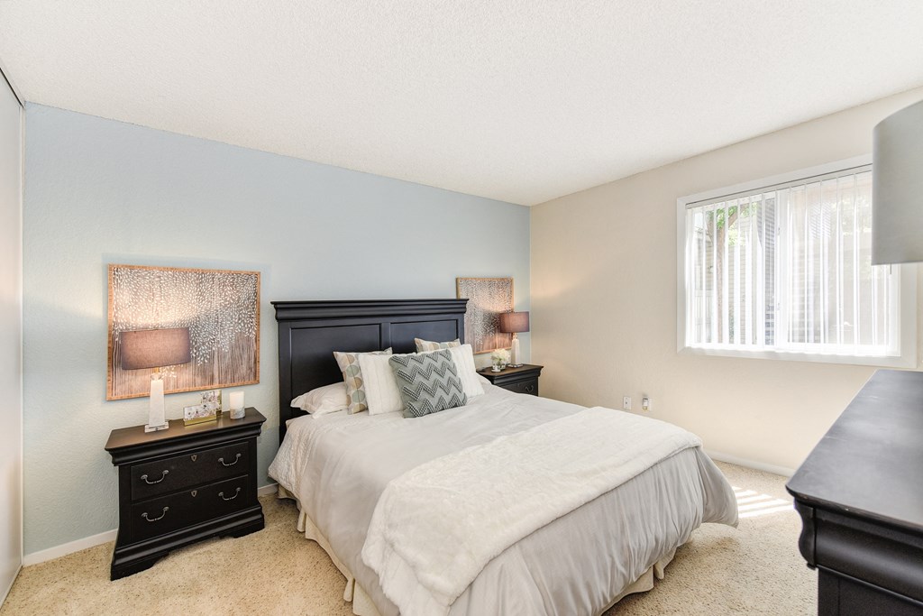 Bedroom with Carpet, Black Headboard, Window and Bedside Dresser at The Renaissance Apartments, California